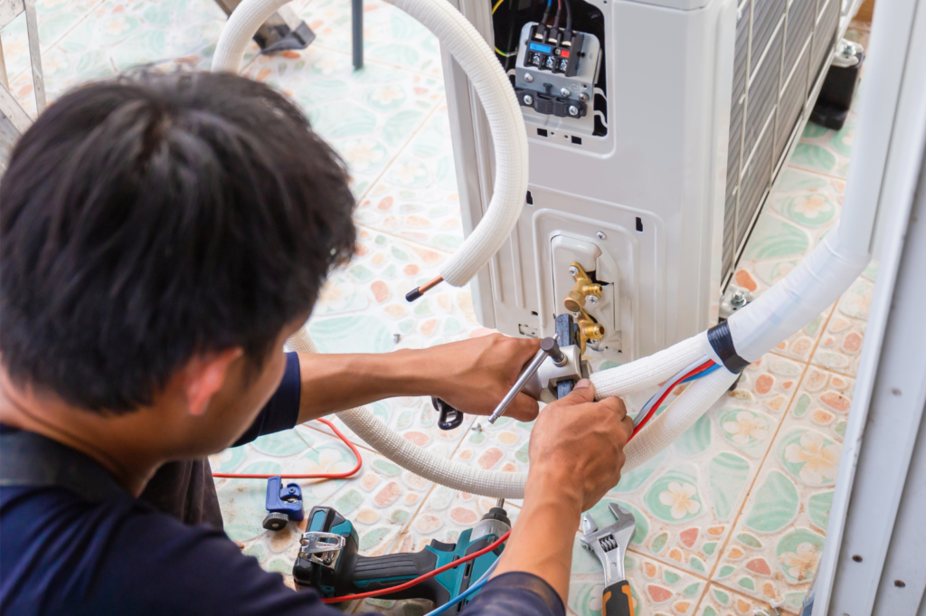 エアコンを分解掃除している業者の男性