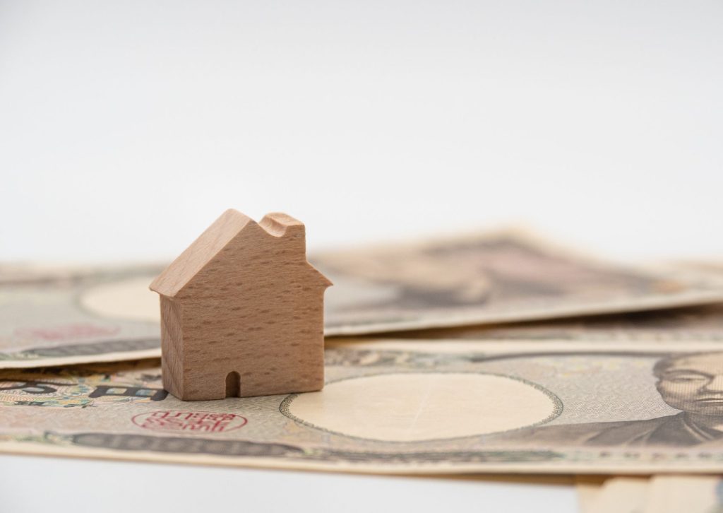 万札の上に木のおもちゃの家