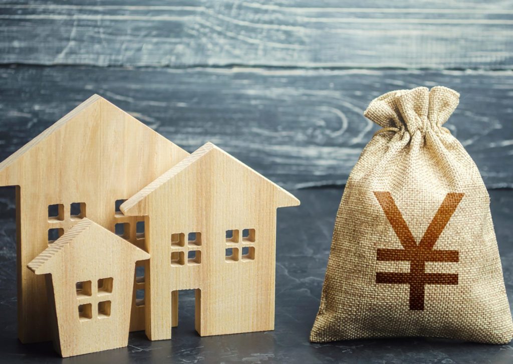 家形の板と￥マークの付いた麻袋