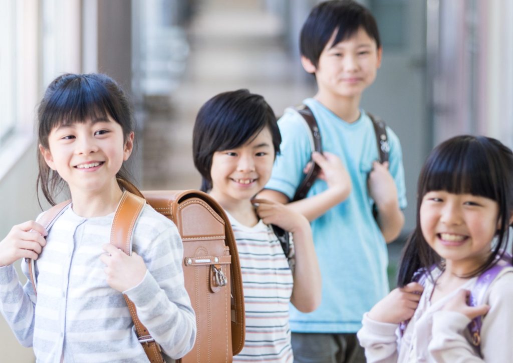 4人の男女の小学生が楽しそうにランドセルをしょっている