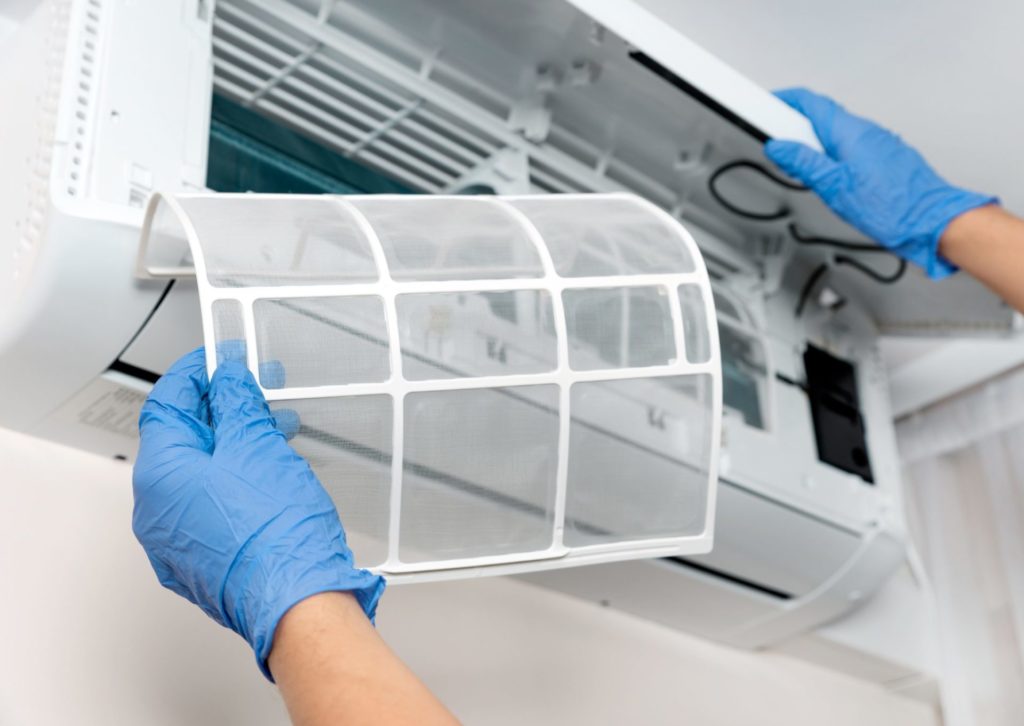 エアコンのフィルターを取り付けている業者