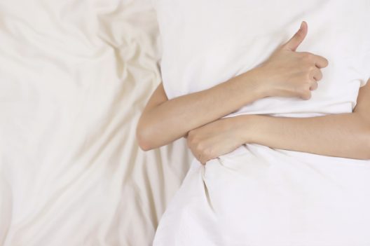 体に合わないマットレスで寝ている女性