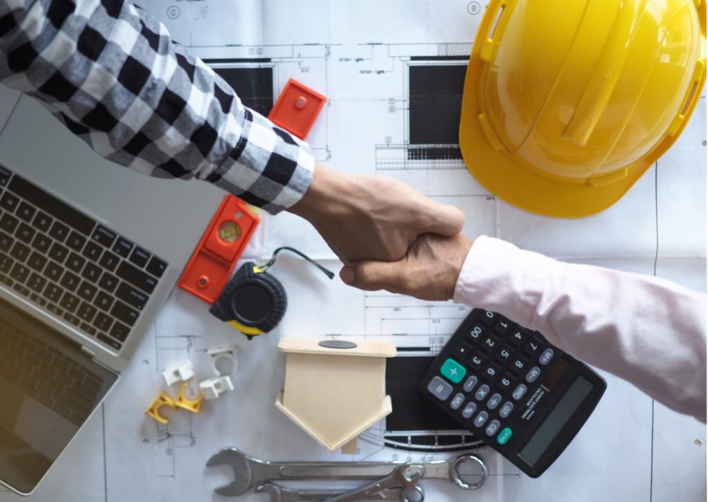 施主と業者が設計図と電卓の上で握手している