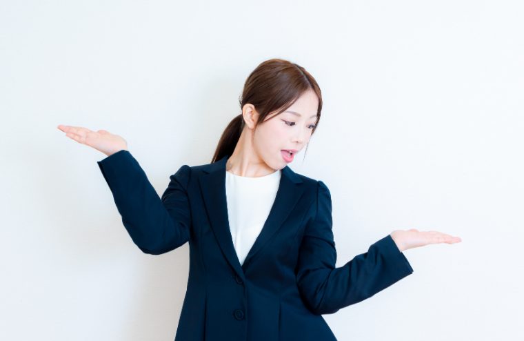 両手を横に出し比較している女性